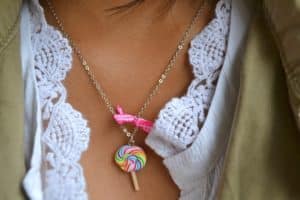 Gros plan du collier bonbon sucette multicolore portée par Léna